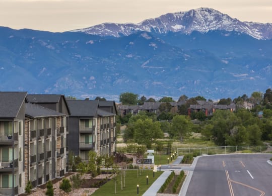 an aerial view of apartment buildings with mountains in the background