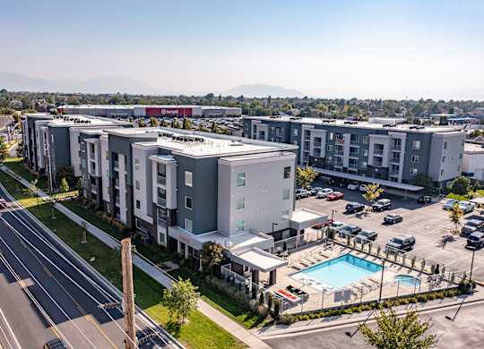 A large apartment complex with a pool and a parking lot.
