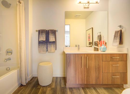 a bathroom with wooden cabinets and a white bathtub