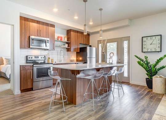 a kitchen with a large island with three stools
