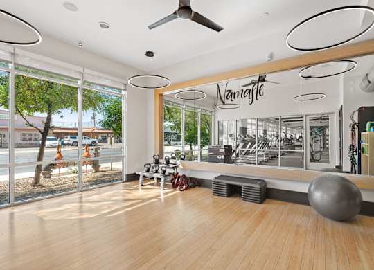 A gym with a wooden floor and a mirror on the wall.