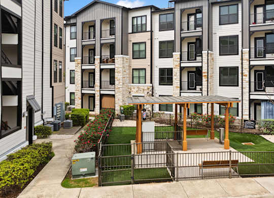 A modern apartment complex with a courtyard and a gazebo.