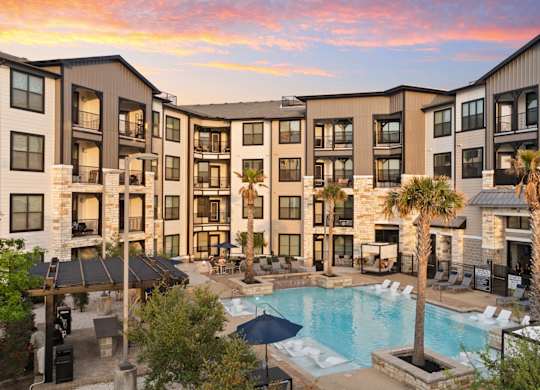 A large apartment complex with a pool in the foreground.
