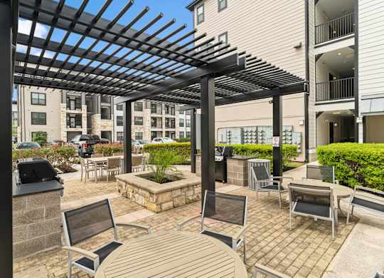 A patio with a black pergola and benches.