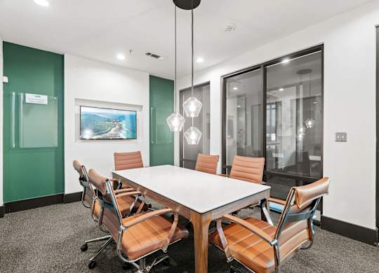 A conference room with a long table and chairs.