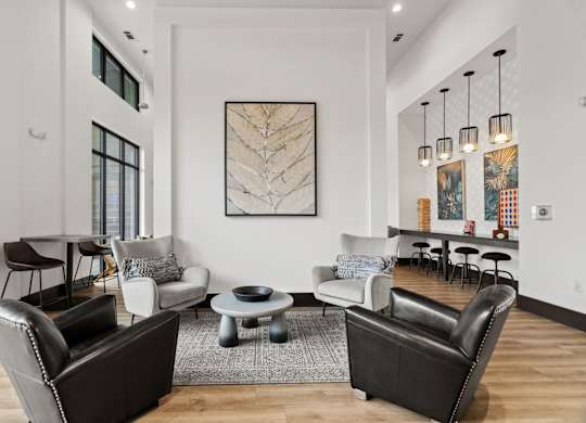A living room with a large painting on the wall and a variety of seating options.