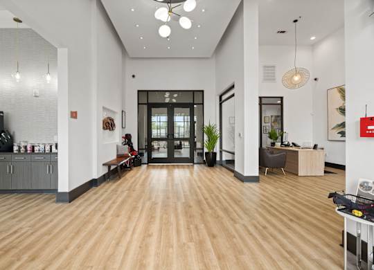 A modern office lobby with a wooden floor and white walls.
