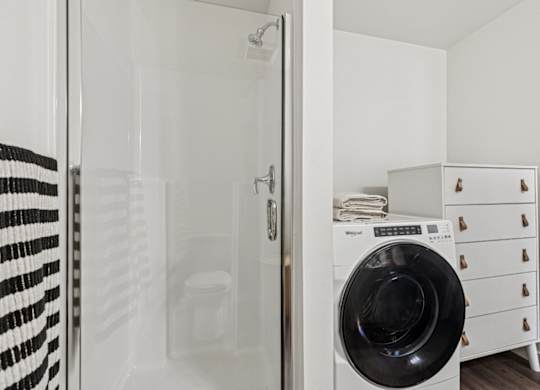 A black and white striped towel hangs on a glass door.