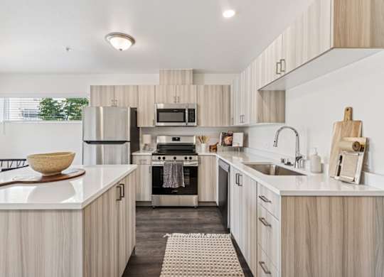 A modern kitchen with wooden cabinets and stainless steel appliances.