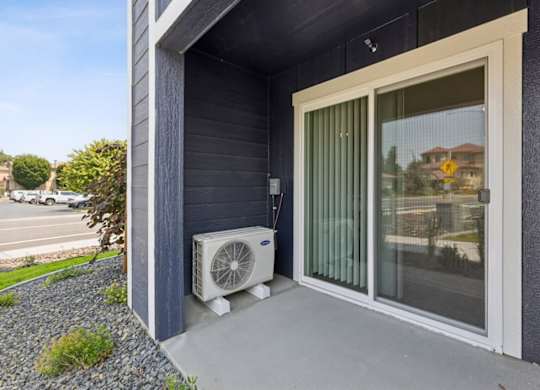 A house with a window and a fan outside.