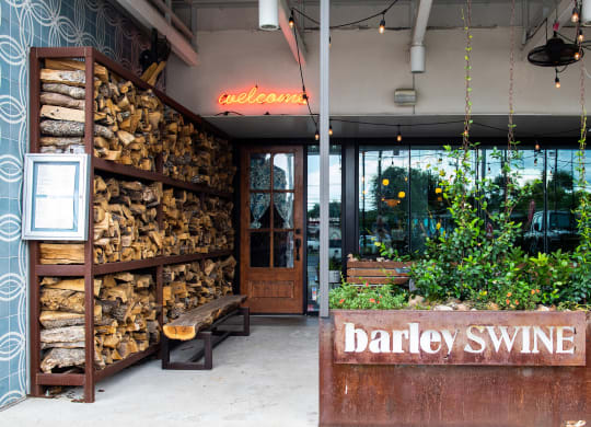the entrance to barley swine with a wall of firewood