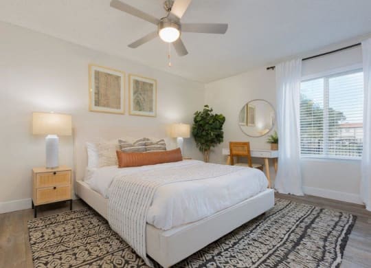 a bedroom with a bed and a ceiling fan