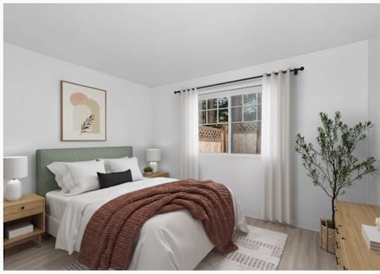 A bedroom with a bed, nightstand, and a window with curtains.
