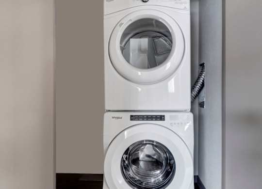 Two white washing machines stacked on top of each other.