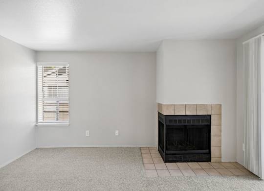 A room with a fireplace and a window with blinds.