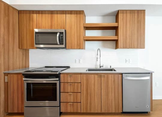 A modern kitchen with wooden cabinets and stainless steel appliances.
