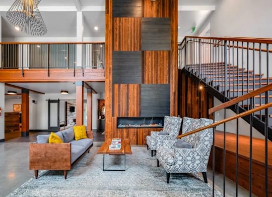 A living room with a fireplace and a staircase.