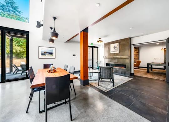 A modern dining room with a wooden table and chairs.