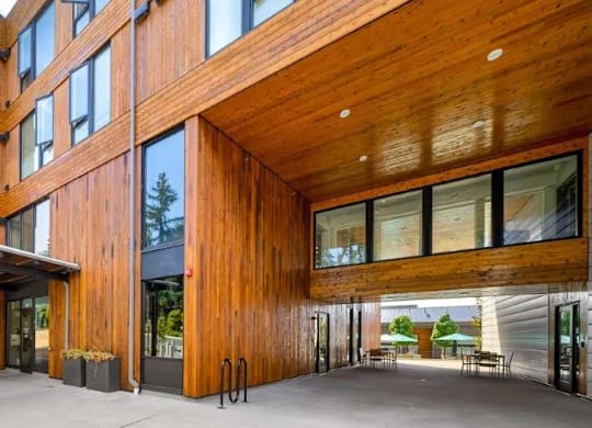 A modern building with wooden exterior and glass windows.