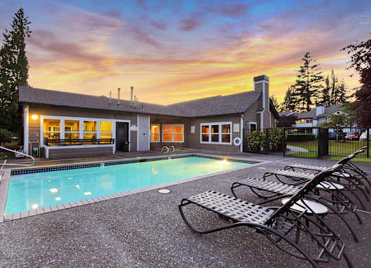 A house with a pool in front of it.