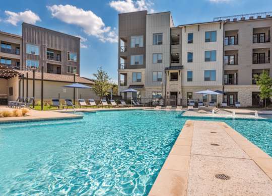 A swimming pool in front of apartment buildings.