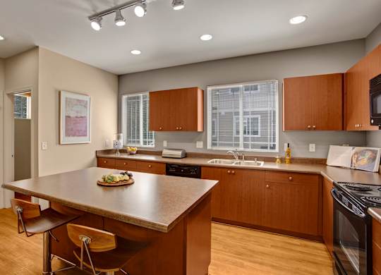 A kitchen with brown cabinets and a wooden island.