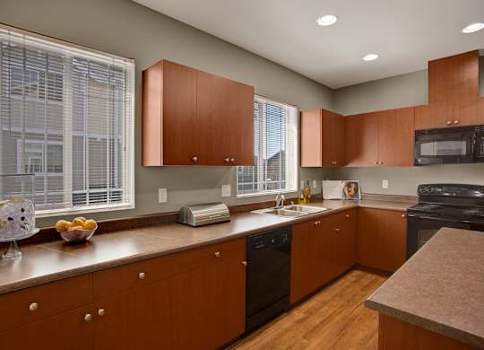 A kitchen with wooden cabinets and a black oven.
