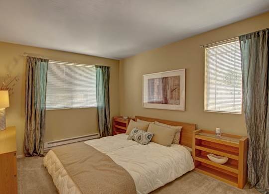 A bedroom with a large bed and a nightstand.