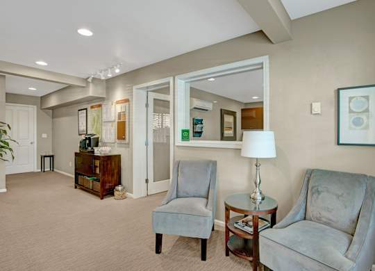 A living room with two chairs and a lamp.