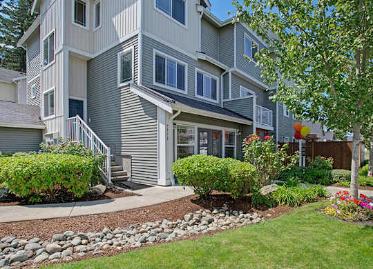 A grey two story house with a front yard.