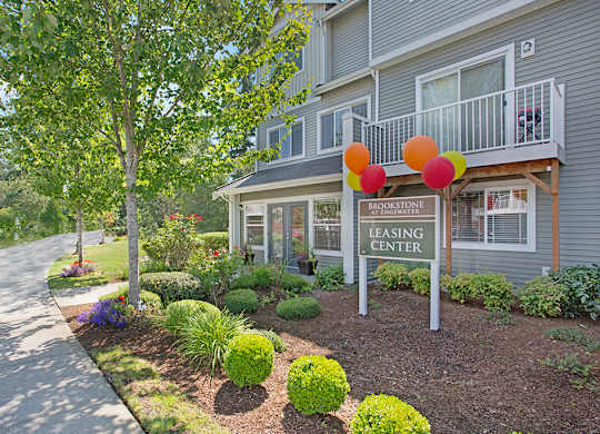 A leasing center for Brookstone is shown with a well kept garden.