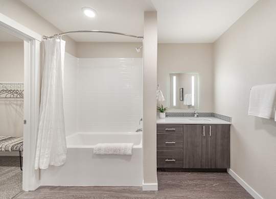 A bathroom with a white tub and sink.