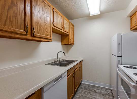 A kitchen with wooden cabinets and a white refrigerator.