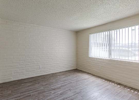 A room with white brick walls and wooden flooring.