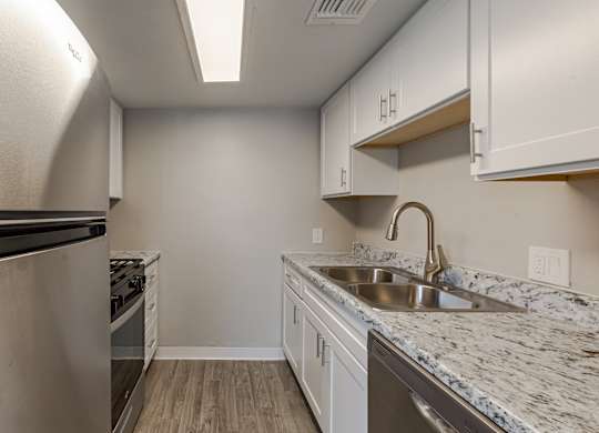 A kitchen with a sink and a refrigerator.