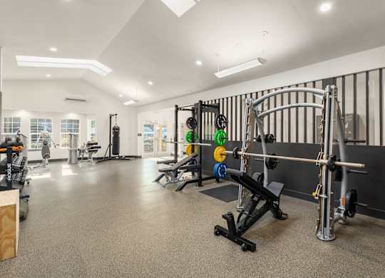 A gym with a variety of equipment including weights and machines.
