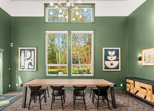 A room with green walls and a table with chairs.