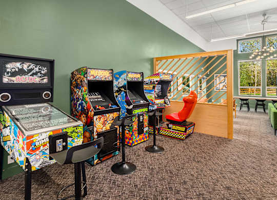 A room with arcade machines and chairs.