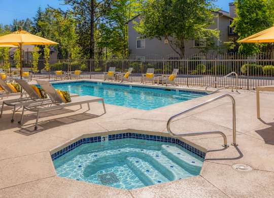 A small pool with a hot tub in the middle of it.