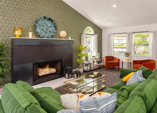 A living room with a fireplace and a green couch.