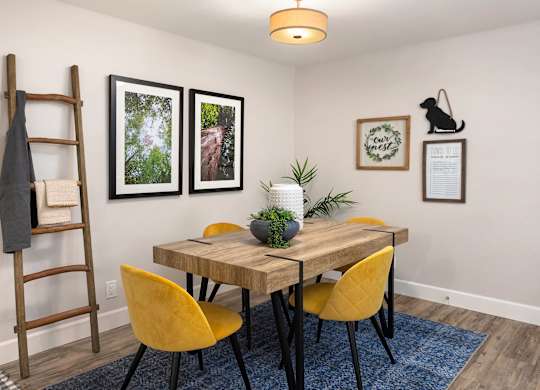 A dining room with a wooden table and yellow chairs.