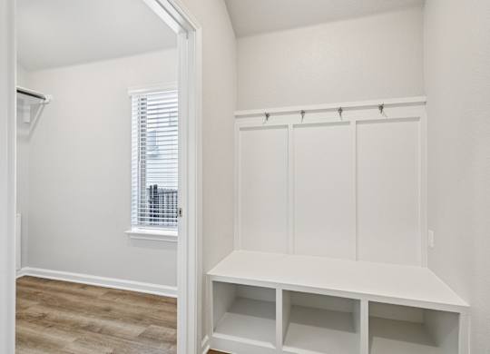 A white closet with a window and shelves.