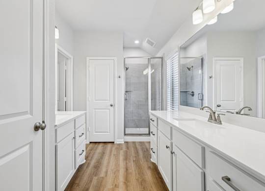A white bathroom with a walk-in shower and a vanity.