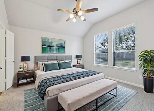 A bedroom with two beds and a ceiling fan.