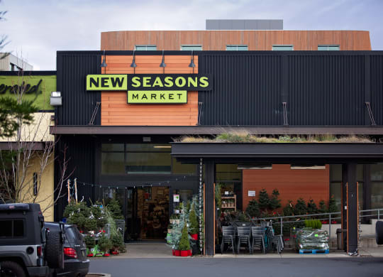 the front of new seasons market with cars parked outside