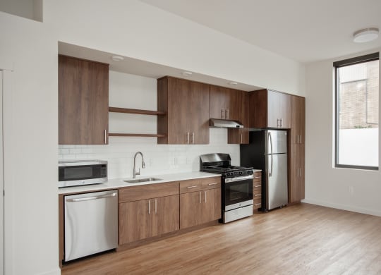 a kitchen with wooden cabinets and stainless steel appliances and a window