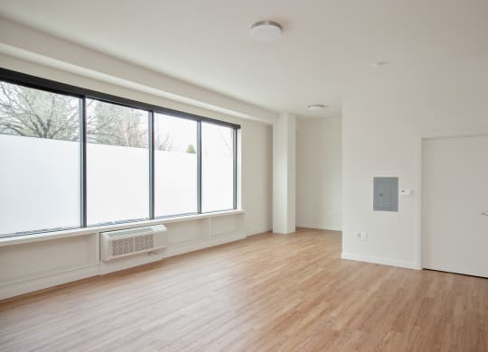 a living room with a large window and wood floors
