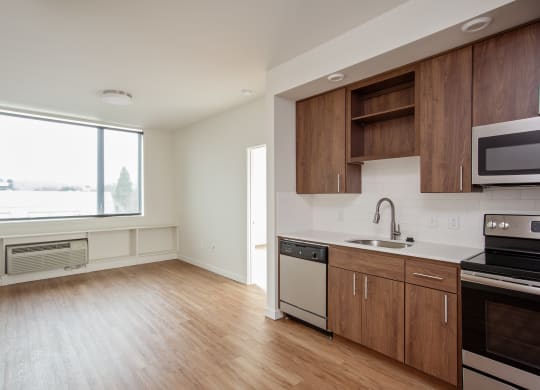 an empty kitchen with wood flooring and a window