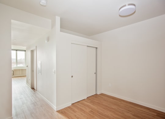 a living room with white walls and a wood floor