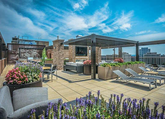 A rooftop patio with seating and a fireplace